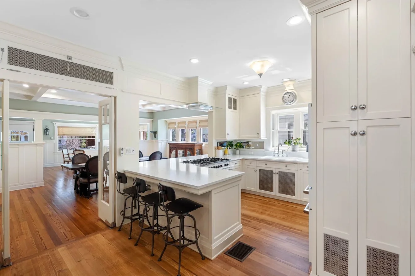 Kitchen with cream cabinetry, white quartz counters, gas cooktop, and wood island with seating